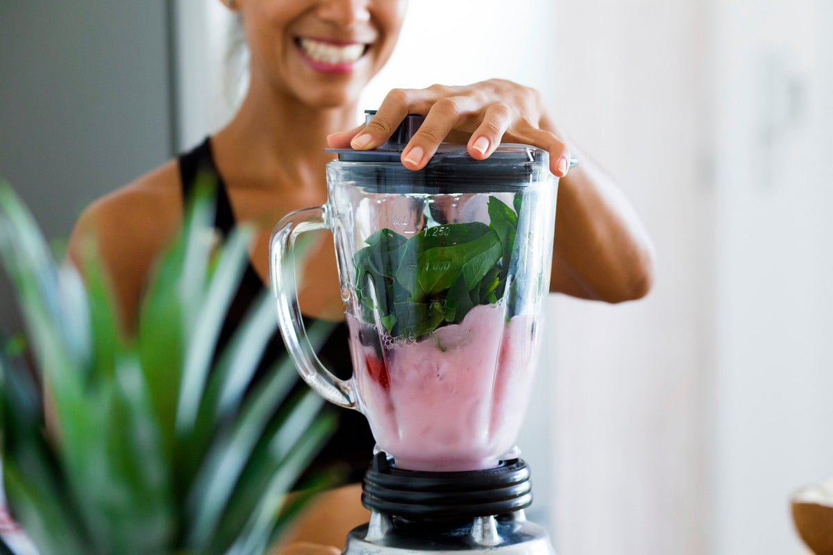 Making a fruit and greens smoothie in a blender
