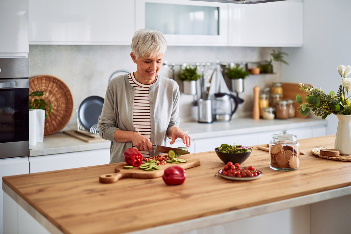Woman preparing a healthy meal with fresh vegetables in her kitchen
